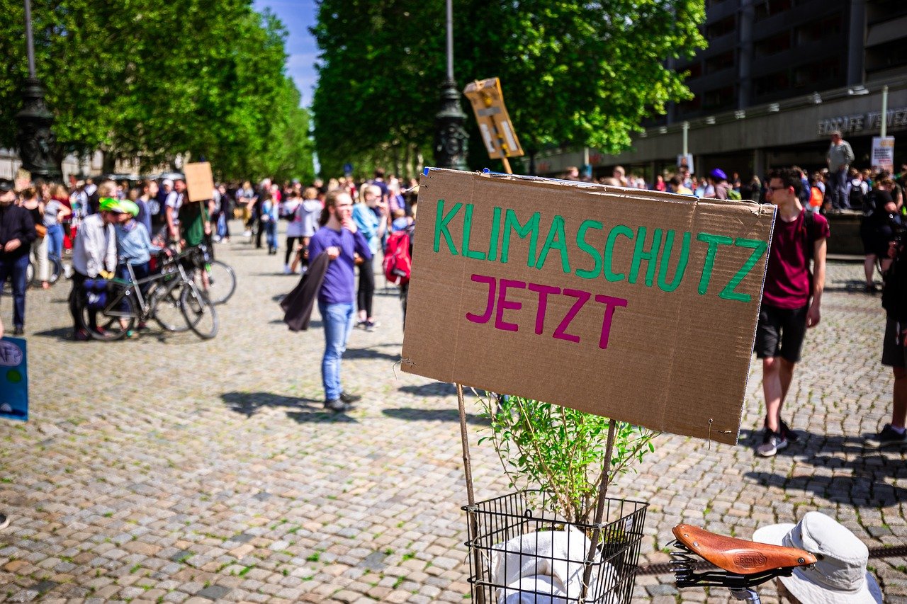 Demo für Klimaschut. Papp-Plakat mit Aufschrift "Klimaschutz jetzt!"