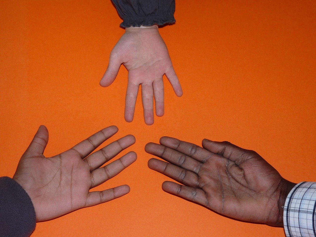 Drei Hände mit unterschiedlicher Hautfarbe