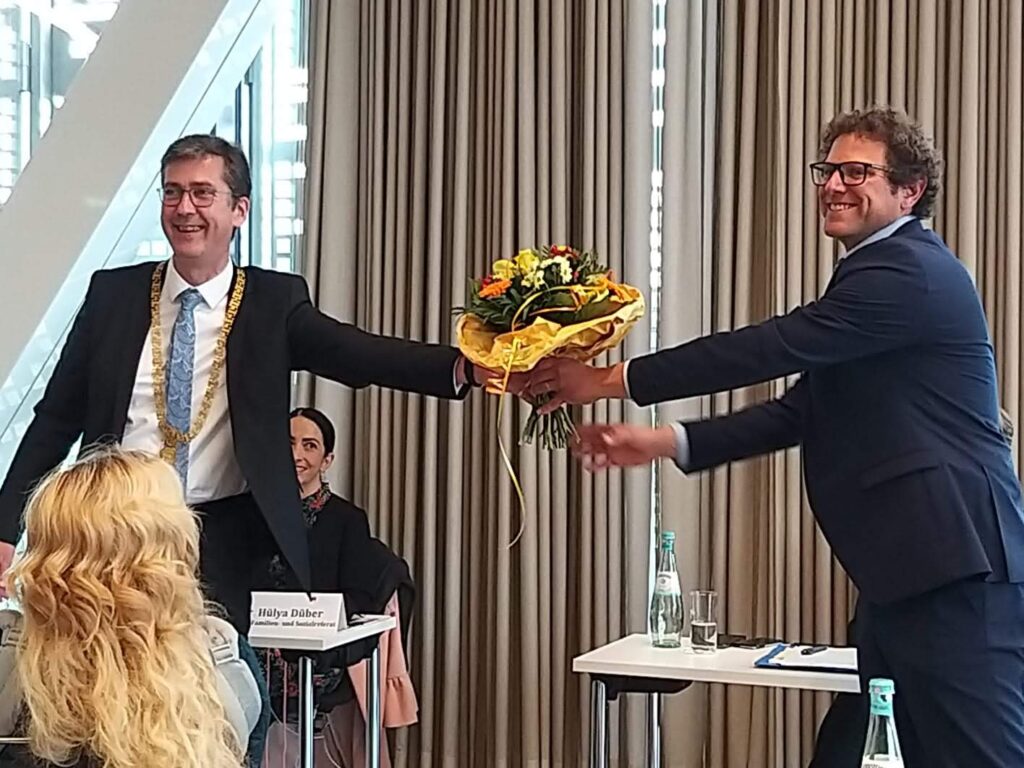 Oberbürgermeister Christian Schuchardt überreicht dem neuen Klimabürgermeister Martin Heilig einen Blumenstrauß