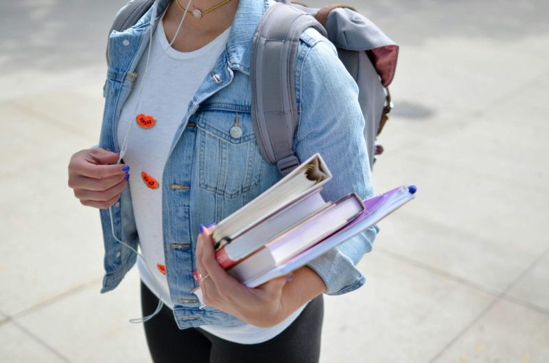 Jugendliche Schülerin mit Bücherin in der Hand